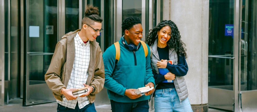 Three young people in front of a building