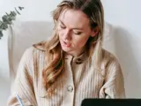 A woman sat at a desk writing