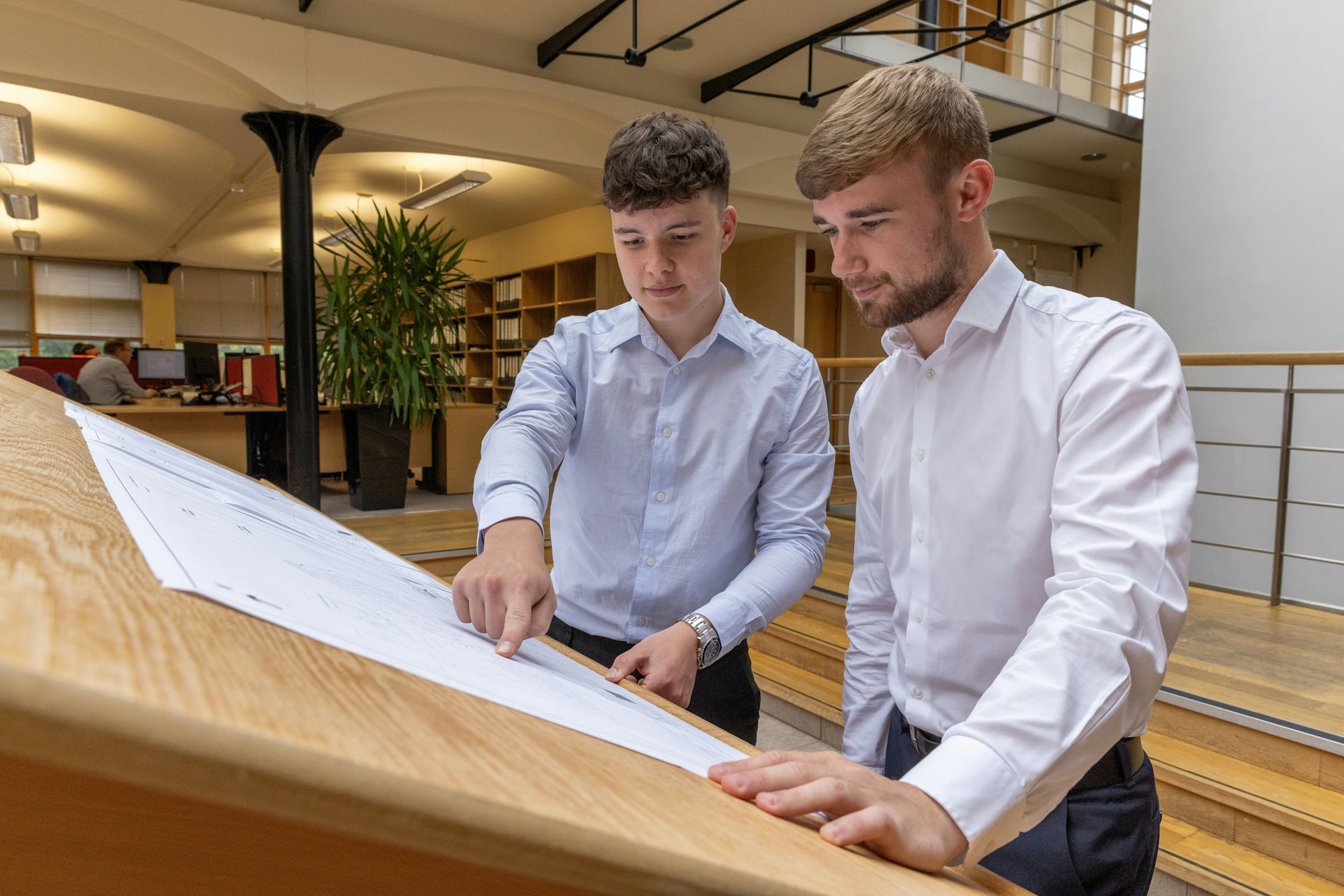 Two young men looking at a plan in an office