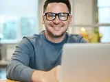 A man sat at a desk with a laptop