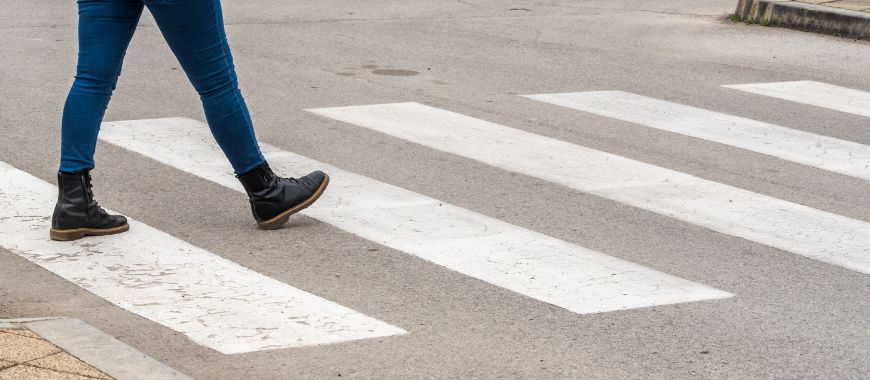 A person walking across a pedestrian crossing